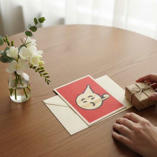 Lokta Cards hand-carved greeting card with a blowing kiss emoji design on red Lokta paper.